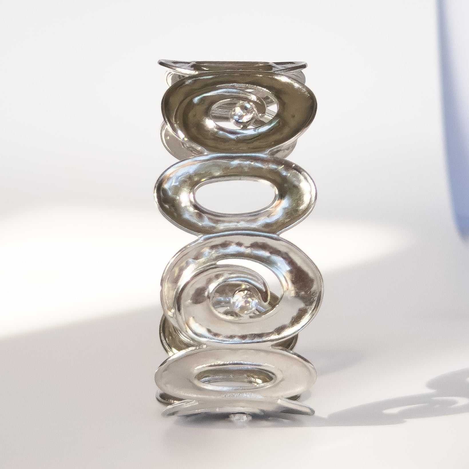 Silver bracelet with interlocking circular links on a white background